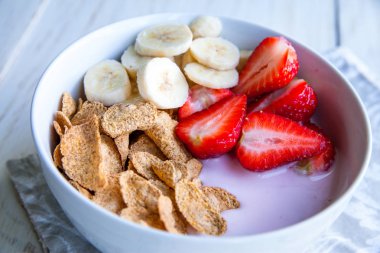 Sağlıklı kahvaltı dahil mısır gevreği ve oatflakes, yoğurt, muz ve çilek