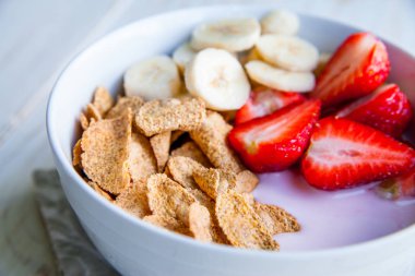 Sağlıklı kahvaltı dahil mısır gevreği ve oatflakes, yoğurt, muz ve çilek