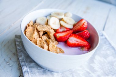 Sağlıklı kahvaltı dahil mısır gevreği ve oatflakes, yoğurt, muz ve çilek