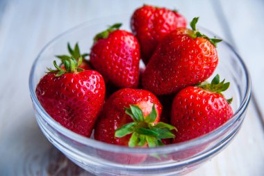 Kahvaltı için Beyaz ahşap zemin üzerinde plaka üzerinde çilek 