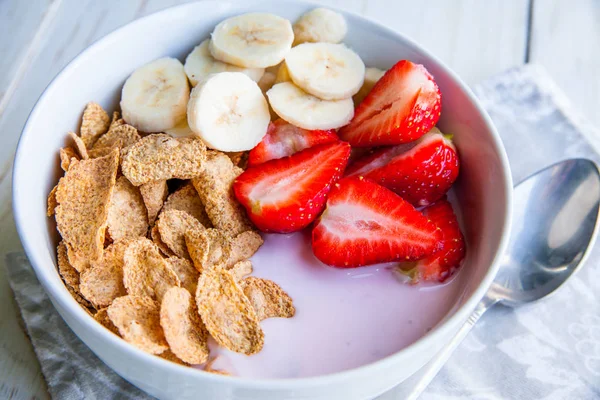 Gesundes Frühstück mit Cornflakes und Haferflocken, Joghurt, Bananen und Erdbeeren — Stockfoto