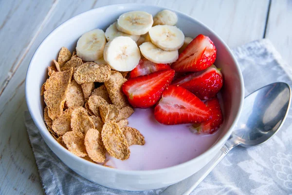 Egészséges reggeli, amely tartalmazza a búzapehely, kukoricapehely, joghurt, banán és eper — Stock Fotó