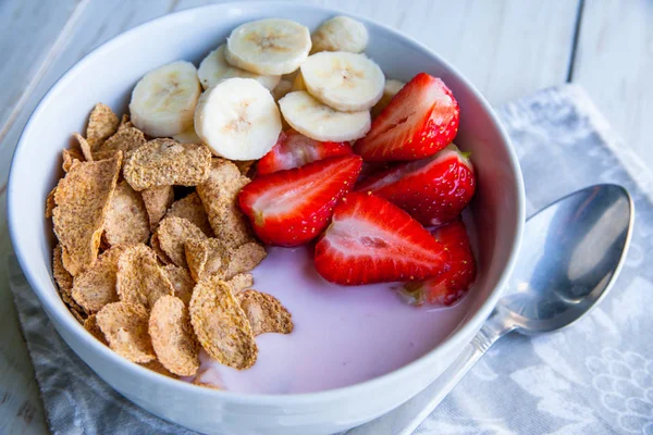 Sağlıklı kahvaltı dahil mısır gevreği ve oatflakes, yoğurt, muz ve çilek