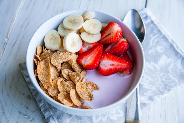 Sağlıklı kahvaltı dahil mısır gevreği ve oatflakes, yoğurt, muz ve çilek