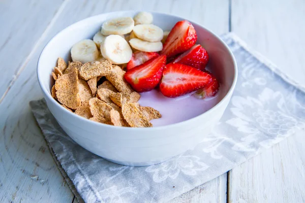 Sağlıklı kahvaltı dahil mısır gevreği ve oatflakes, yoğurt, muz ve çilek