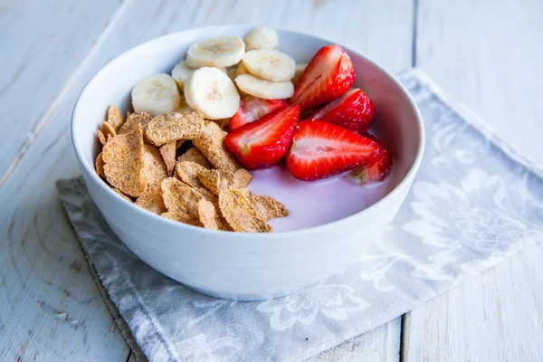 Sağlıklı kahvaltı dahil mısır gevreği ve oatflakes, yoğurt, muz ve çilek