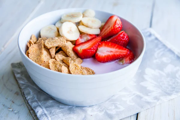 Sağlıklı kahvaltı dahil mısır gevreği ve oatflakes, yoğurt, muz ve çilek