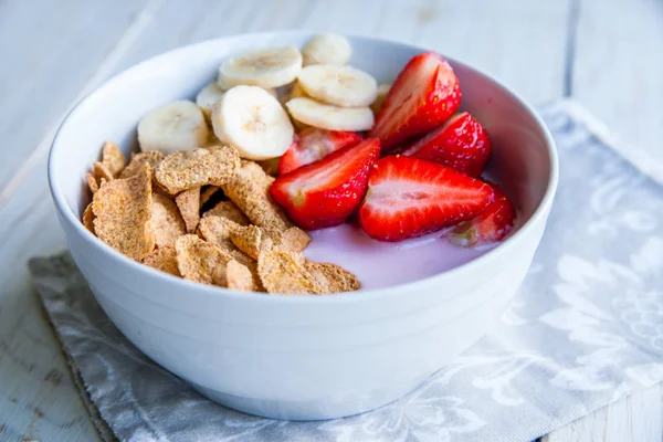 Sağlıklı kahvaltı dahil mısır gevreği ve oatflakes, yoğurt, muz ve çilek