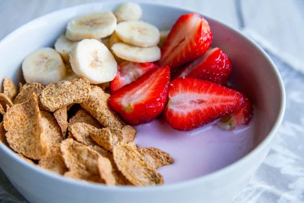 Sağlıklı kahvaltı dahil mısır gevreği ve oatflakes, yoğurt, muz ve çilek