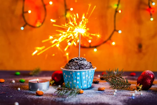 Cupcakes de Navidad con luz, fondo de madera, estrellas y árbol de Navidad — Foto de Stock