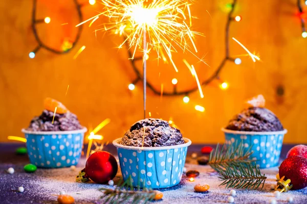 Cupcakes de Navidad con luz, fondo de madera, estrellas y árbol de Navidad — Foto de Stock