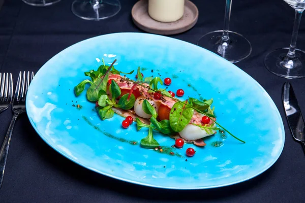 Ensalada con vieiras de mar, albahaca, tocino y arándanos en plato azul servido en el restaurante — Foto de Stock