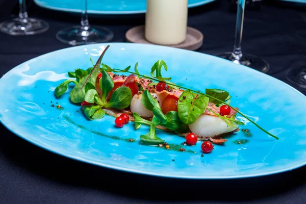 Ensalada con vieiras de mar, albahaca, tocino y arándanos en plato azul servido en el restaurante — Foto de Stock