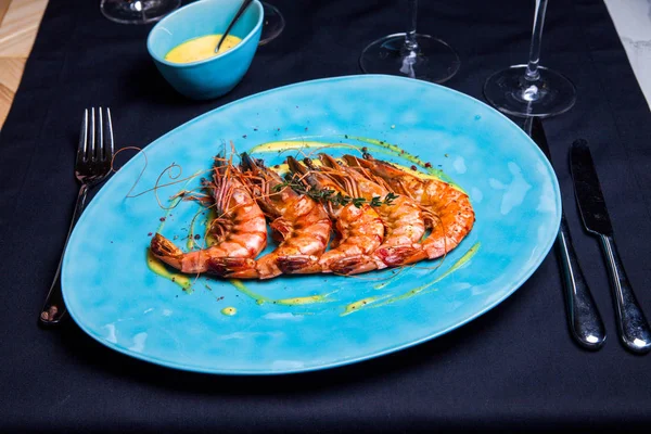 Camarones a la parrilla con romero en el plato azul servido en el restaurante con sous y vino — Foto de Stock