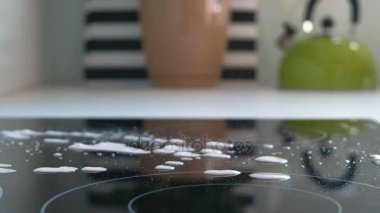 Bir kadın soba yıkar. Sarı eldiven soba indüksiyon yıkama elinde. Kadın ev temizlik 