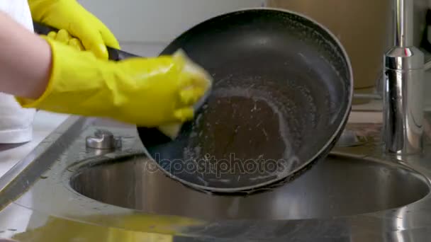 Una mujer está lavando platos en la cocina. Lavado de manos humano platos con agua de bebida fresca en el grifo de la cocina — Vídeo de stock