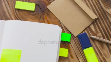 Kadın Notlar not defteri yazın. Ofis, banka donatımı ile açık not etmek. Marker, kalem, kalem ve çıkartmaları ile ahşap bir masaüstünde açık not defteri yatıyor