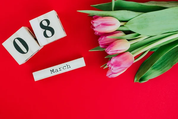 3月8日幸福妇女节的概念 在红色背景下的木制方块日历和粉红色郁金香 — 图库照片