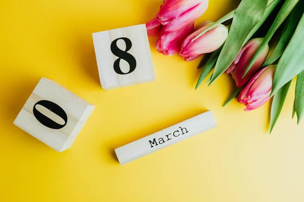 3月8日幸福妇女节的概念 用木制方块日历和粉红色的郁金香在黄色背景 复制空间 — 图库照片