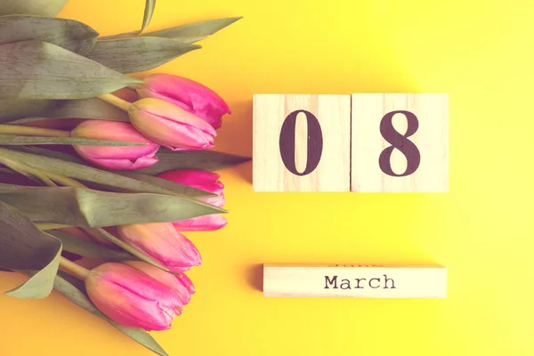 3月8日幸福妇女节的概念 用木制方块日历和粉红色的郁金香在黄色背景 复制空间 — 图库照片