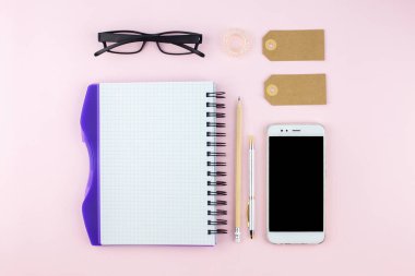 Yaratıcı düz fotoğraf çalışma masası smartphone, gözlük, kalem, kurşun kalem ve defter, pembe bir arka plan üzerinde en az tarzı yatırın. En az iş kavramı