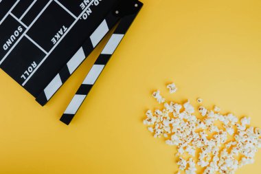 Sinema en az kavramı. Sinemada film izlemek. patlamış mısır, Sarı zemin üzerine clapper kurulu 
