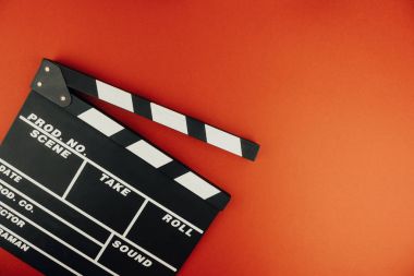 Sinema en az kavramı. Sinemada film izlemek. Clapper kırmızı zemin üzerine kurulu. Screenwrite masaüstü