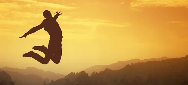 El hombre salta en forma de silueta al atardecer . —  Fotos de Stock