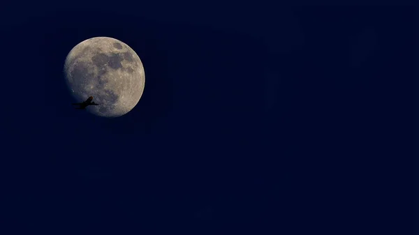 Lityaschy plane on background of the moon. — Stock Photo, Image