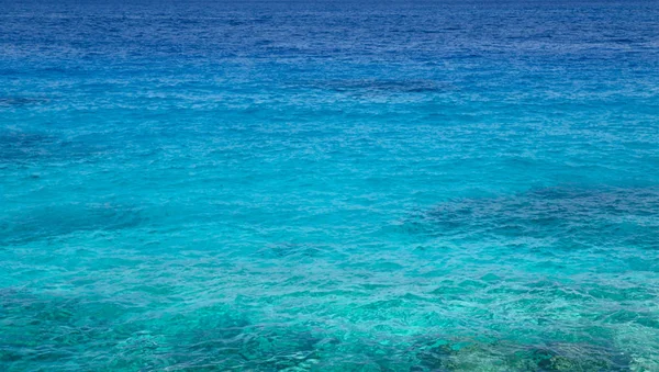 Прозрачная прибрежная вода моря летом . — стоковое фото