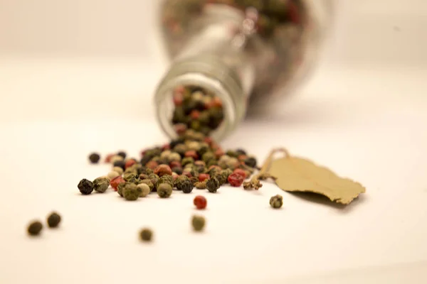 Scattered grains of black pepper and bay leaves — Stock Photo, Image