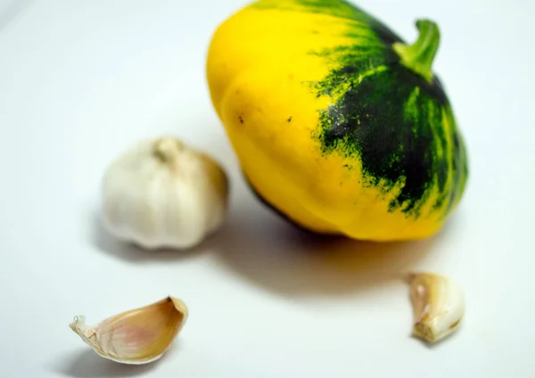 Spotted squash on a white background and garlic — Stock Photo, Image