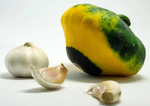 Calabaza manchada sobre un fondo blanco y ajo — Foto de Stock