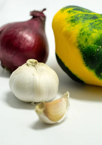 Gefleckter Kürbis auf weißem Hintergrund, Zwiebeln und Knoblauch — Stockfoto