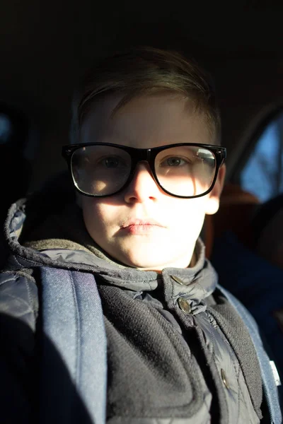 Aranyos fiú keresi, hogy a fényképezőgép fekete szemüveget. — Stock Fotó