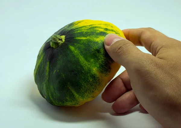 Manchado squash e mão do homem em um fundo branco — Fotografia de Stock