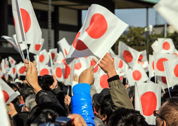 Kalabalık Tokyo yeni yılın ilk gününde İmparatorluk Sarayı önünde kare balkonda altında. Ülke bayrakları Park grubu. 