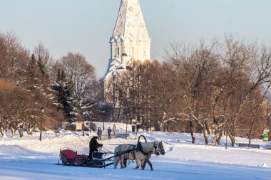 2019.01.09, Moskova, Rusya. Beyaz kilisenin arka planında (unesco dünya mirasından) Kolomenskoye parkında at ve at arabasıyla kış manzarası.