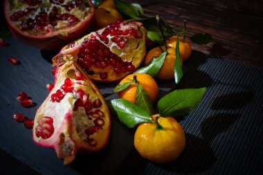 Karanlık anahtarda kırık nar ve mandalina dolu bir hayat. Taze meyve suyu yapmak için malzemelerin bileşimi (meyveler).