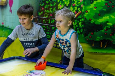 2019.02.10, Maloyaroslavets, Rusya. Bir ağabey, küçüklerin hava hokeyi, bulanıklık ve tahıl efekti oynamasına yardım eder. Çocukların aktif yaşam tarzı.