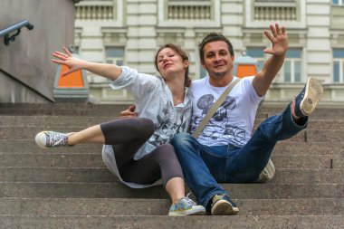 2011.05.21, Moscow, Russia. A young man and woman sitting on the stone staircase and having fun.
