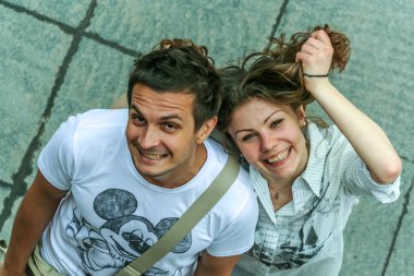2011.05.21, Moscow, Russia. Funny posed young guy and girl close up. Two young people having fun, top of view.