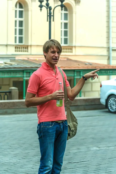 A single young man wearing pink polo having fun by the square, Moscow.