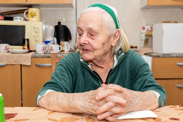 Una Anciana Sentada Junto Mesa Cocina Mirando Hacia Otro Lado —  Fotos de Stock