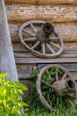 Kırsal bir ahşap evin duvarı ve ahşap araba parçaları, bulanıklık ve tahıl etkisi..