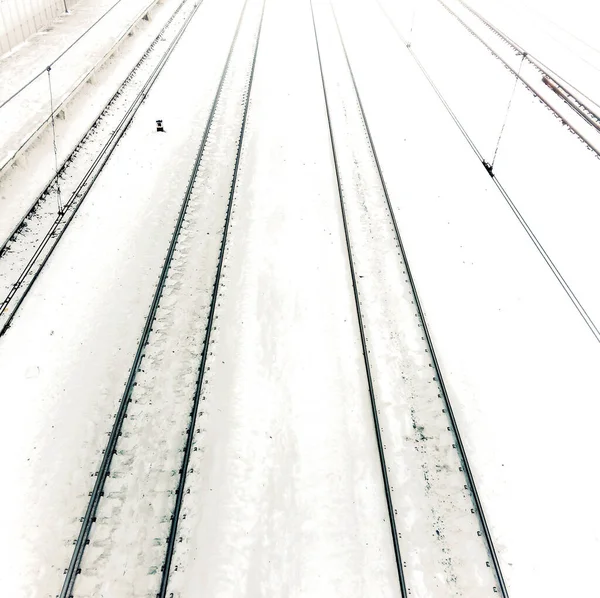 Railway in snow. Winter perspective landscape with empty rail tracks.