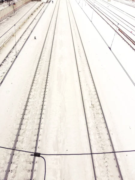 Railway in snow. Winter perspective landscape with empty rail tracks.