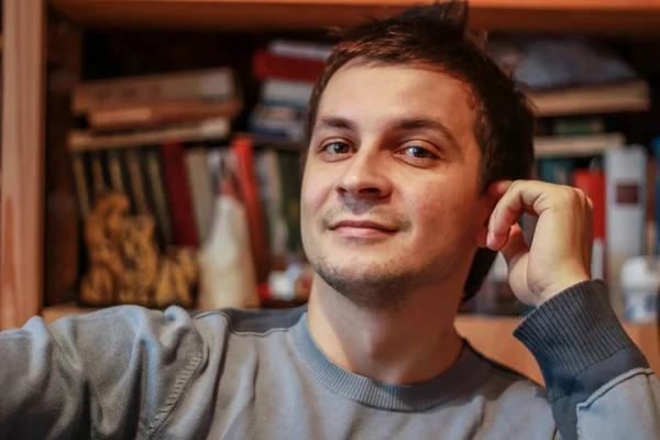 Retrato Joven Sonriente Casa Fondo Estantería Mirando Cámara Tipo Divirtiéndose — Foto de Stock