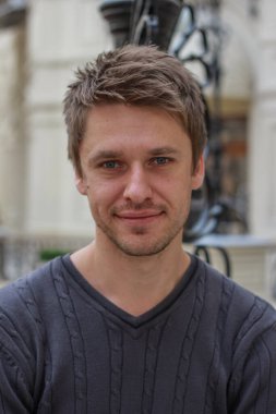 Çekici, sarışın, gülümseyen bir adamın portresi..