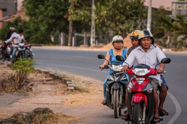 304.2015, Phan Thiet, Vietnam. Yerel Vietnamlı ulusal bir araçla yolda motosiklet sürüyor..